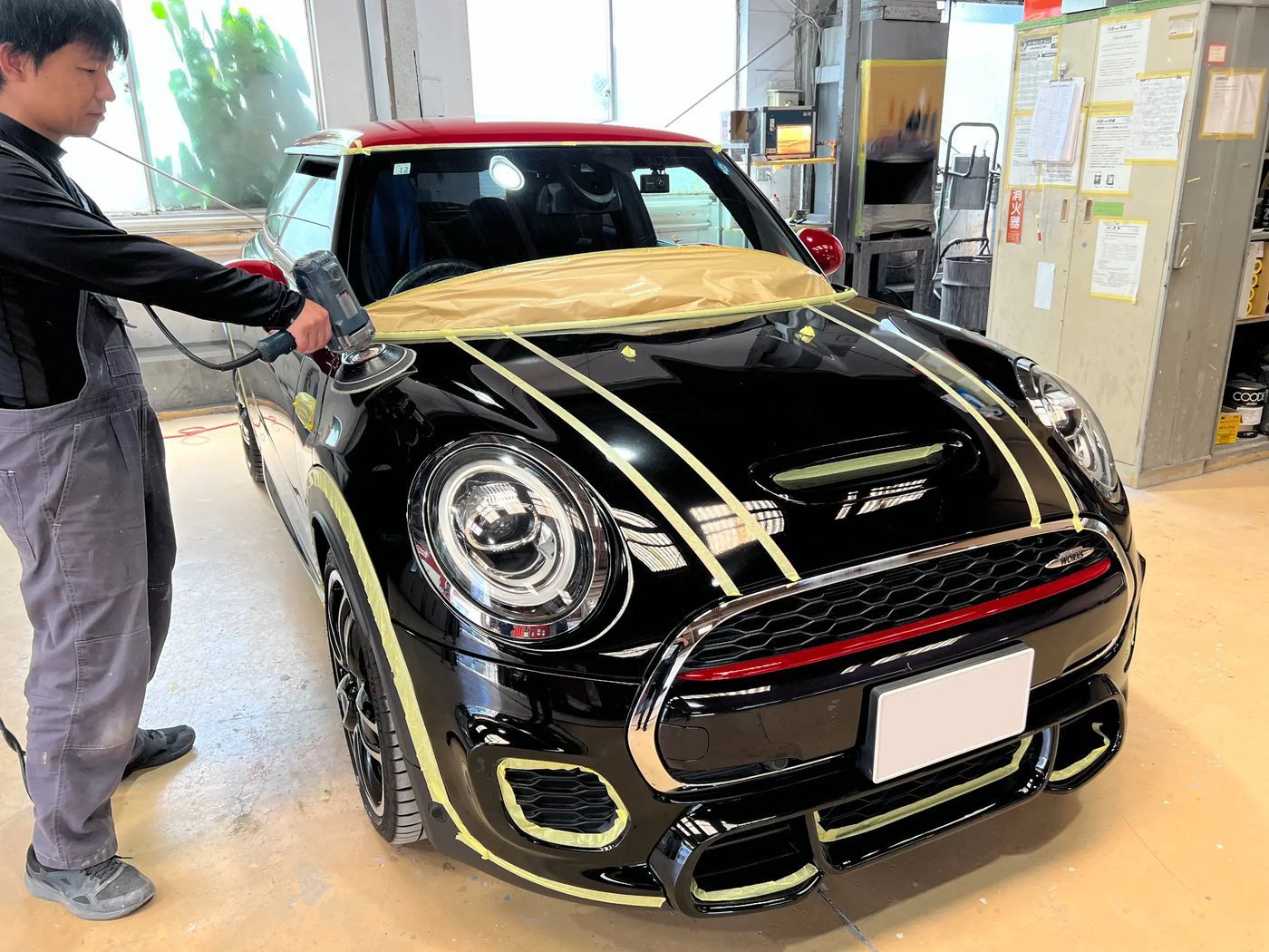 マスキングを施した車両を磨く熟練スタッフ